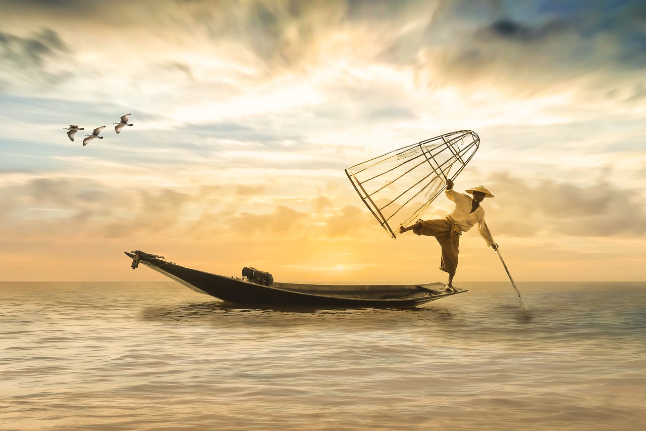 fisherman is with cage and in boat catching fish