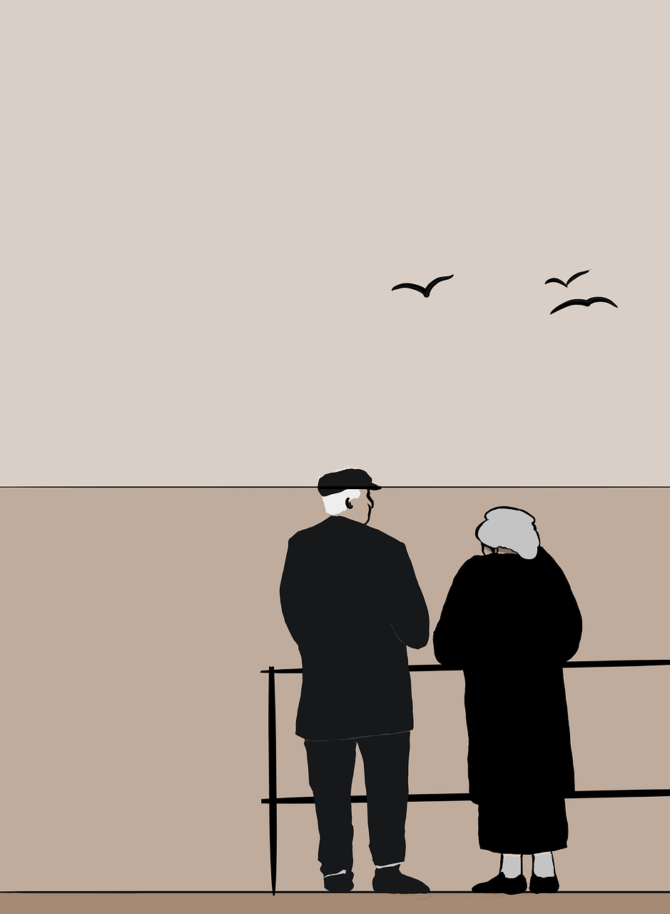 old couple standing and watching sunset