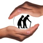 Two hands covering silhouettes of elderly people